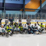 Sled Hockey participants lined up for a photo on the ice after the SPD charity game.
